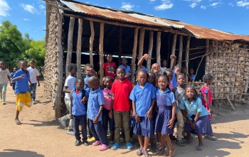 Djeca zajedno vani ispred škole u Mozambiku.